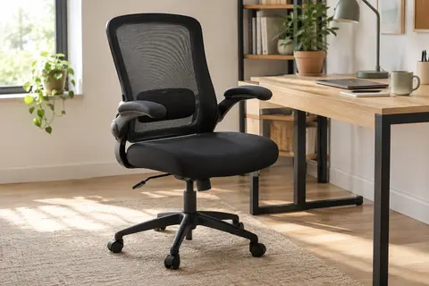 Chaise de bureau noire en maille avec soutien lombaire et accoudoirs relevables près d’un bureau en bois clair.