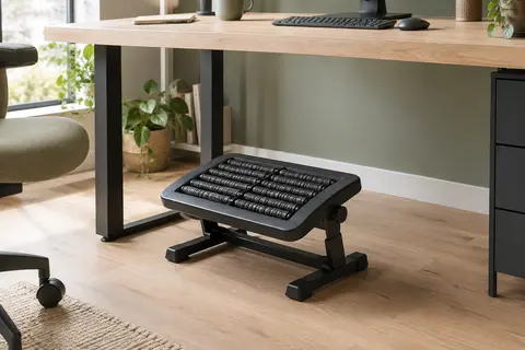 Repose-pieds de bureau noir avec rouleaux, installé sous un bureau en bois clair